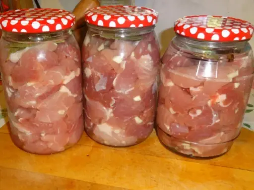 Trzy słoiki z mięsem na gulasz, gotowe do pasteryzacji. Zastanawiasz się, jak długo pasteryzować gulasz w słoiku?