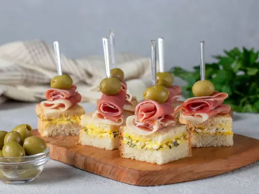 Mini kanapki z szynką, jajkiem i oliwkami na patyczkach. Idealne, tanie przekąski na imprezę, które zachwycą gości.