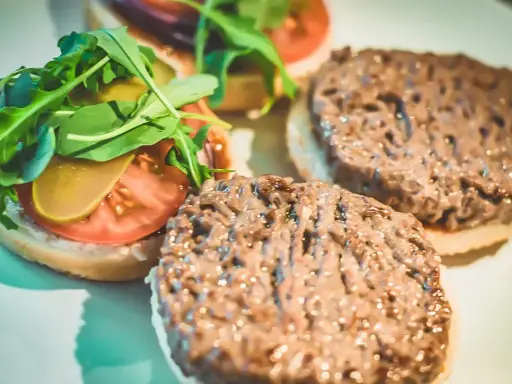 Gotowe hamburgery z Biedronki: jak przyrządzić pyszne burgery z rukolą, pomidorem i ogórkiem.