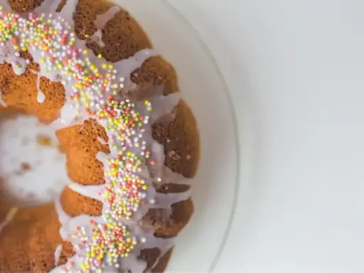 Babka z kolorową posypką i lukrem pomarańczowym, gotowa na święta.