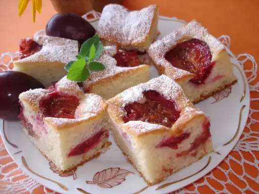 Pyszne ciasto ze śliwkami na oleju i jogurcie, posypane cukrem pudrem. Idealne na deser!