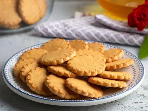 Stos pysznych, szybkich kruchych ciasteczek na talerzu z niebieskim wzorem. Idealne na popołudniową herbatkę.