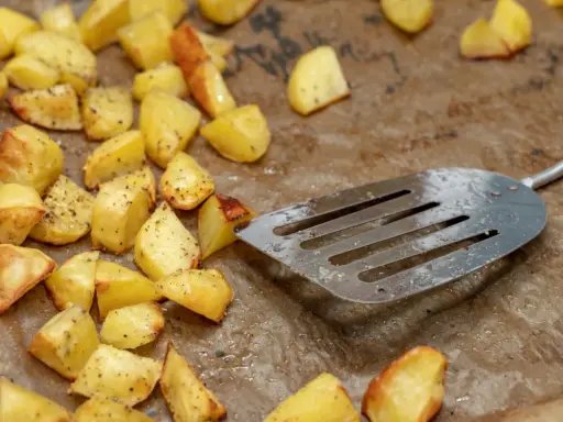 Upieczone ziemniaki na blasze, gotowe do podania. Prosty sposób, jak upiec surowe ziemniaki w piekarniku, by były chrupiące.