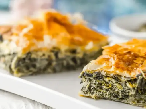 Chrupiąca, złocista spanakopita z warstw ciasta filo i aromatycznym nadzieniem ze szpinaku i sera feta.
