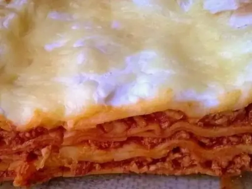 Warstwy makaronu, sosu mięsnego i sera tworzą apetyczny przekrój lasagne. Idealny prosty przepis na lasagne z mięsem mielonym.