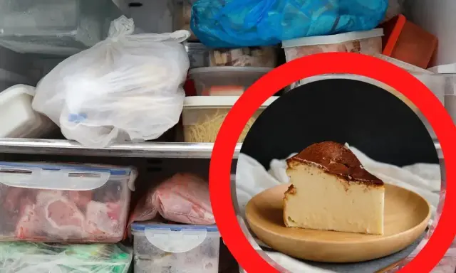 Kawałek sernika na talerzyku, otoczony zamrożonymi produktami w zamrażarce. Czy sernik można mrozic? Tak, można go mrozić.