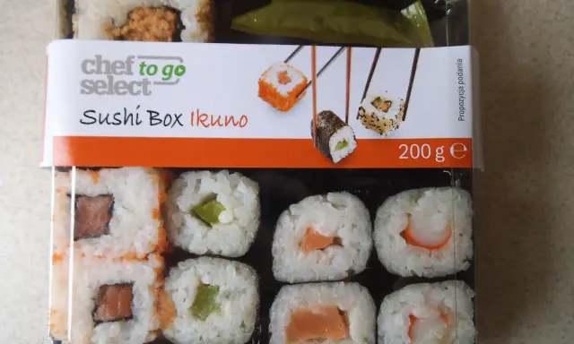 Pudełko z **lidl sushi** Chef to Go Select Ikuno, zawiera różne rodzaje rolek z łososiem, awokado i krewetkami.