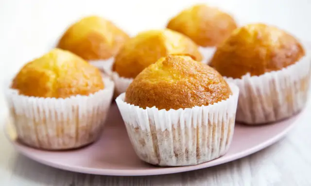 Puszyste muffinki na talerzyku, idealne do kawy. Ten przepis na wilgotne i puszyste muffinki sprawi, że będą smakować wybornie.