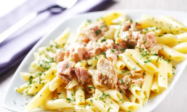 Penne z tuńczykiem w sosie własnym, posypane natką pietruszki. Proste i pyszne danie.