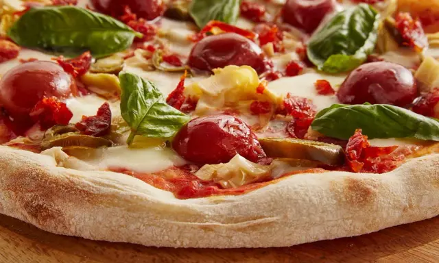 Pyszna pizza włoska z pomidorkami, mozzarellą i bazylią. Idealny przepis na domową ucztę.