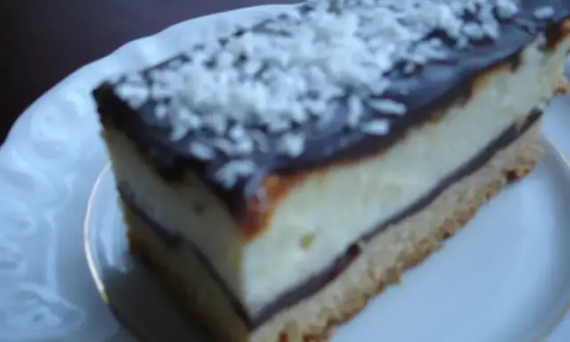 Szybkie ciasto z białym serem i budyniem, polane czekoladą i posypane wiórkami. Idealne na deser.