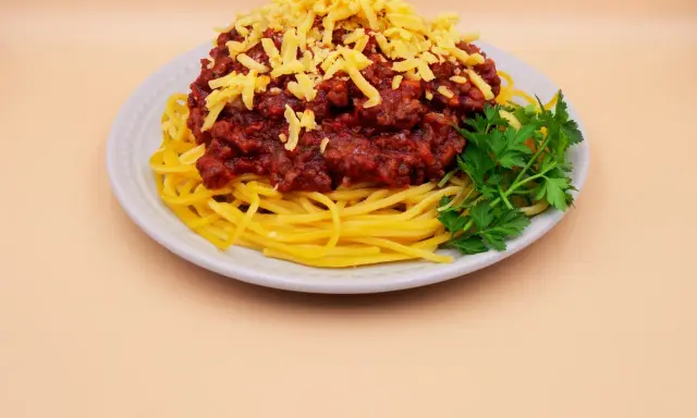 Spaghetti bolognese z tartym serem i natką pietruszki. Prosty przepis na pyszny obiad.