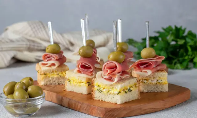 Mini kanapki z szynką, jajkiem i oliwkami na patyczkach. Idealne, tanie przekąski na imprezę, które zachwycą gości.