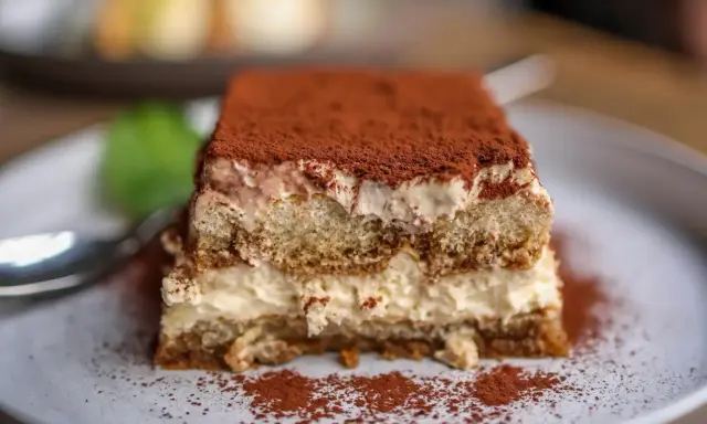 Pyszny kawałek tiramisu z mascarpone, posypany kakao. Idealny na deser, gdy szukasz sprawdzonego przepisu.