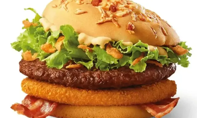 Apetyczny burger drwala z chrupiącym plackiem cebulowym, soczystą wołowiną, chrupiącym boczkiem i świeżą sałatą.