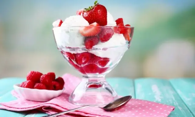 Pyszne lody nuii z malinami i truskawkami w pucharku.