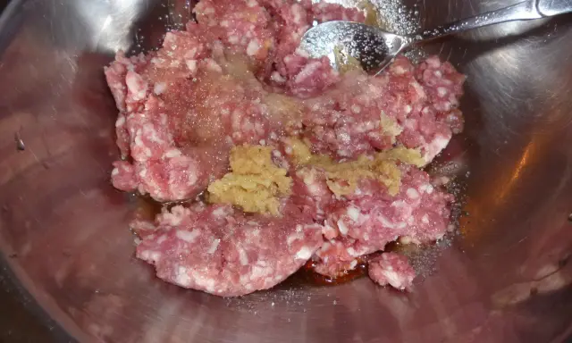 Mielone mięso z dodatkami, gotowe do przygotowania soboro. W metalowej misce znajduje się surowe mięso mielone, przyprawy i sos.