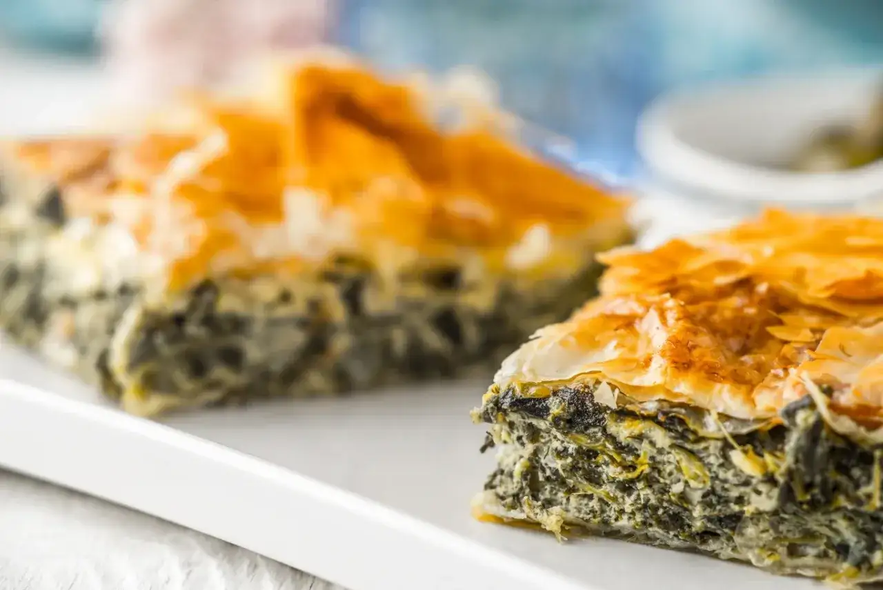 Chrupiąca spanakopita z warstw ciasta filo i nadzieniem ze szpinaku i sera feta.