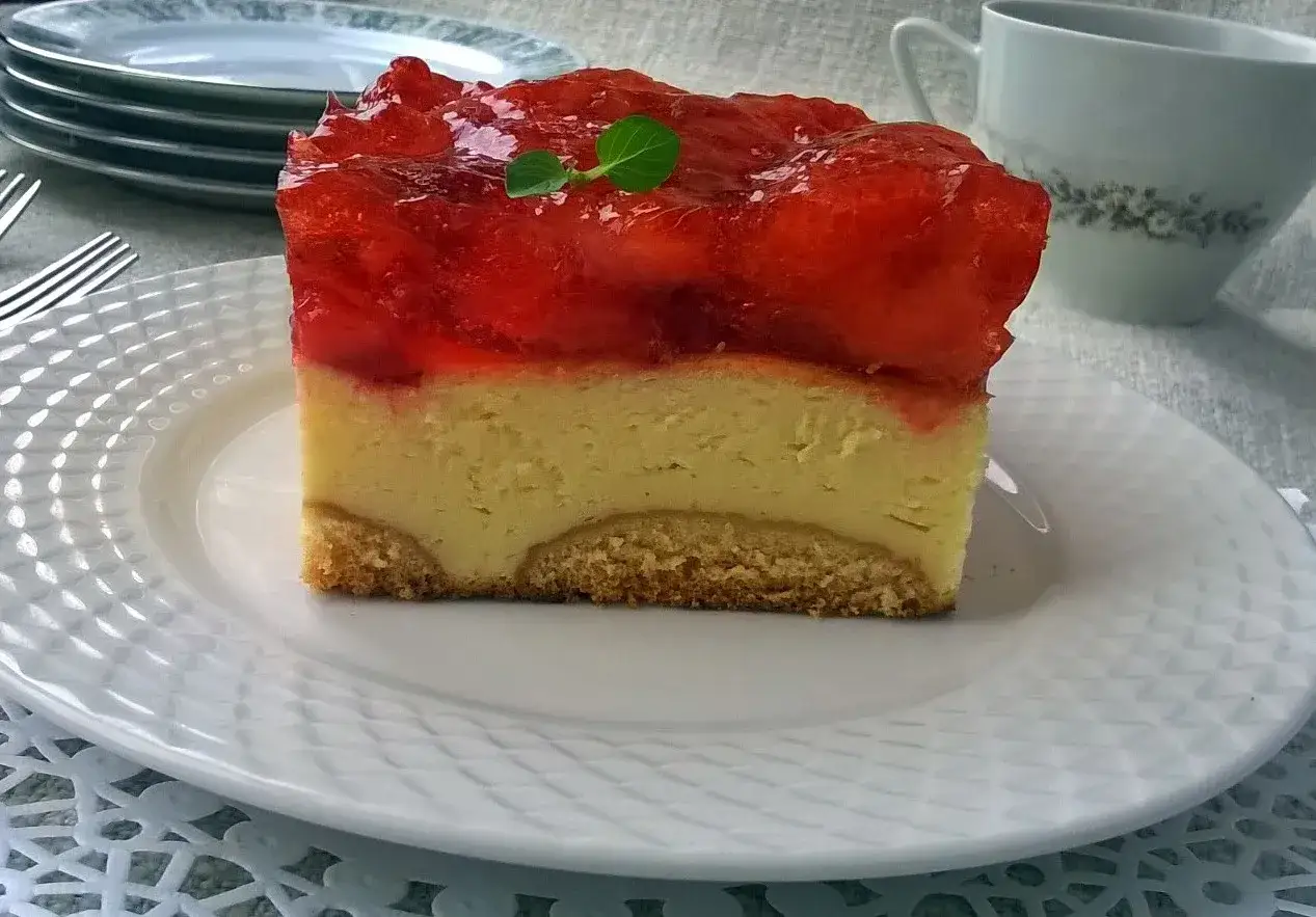 Pyszny sernik pieczony z galaretką na wierzchu, z kawałkami owoców. Idealny deser na każdą okazję.
