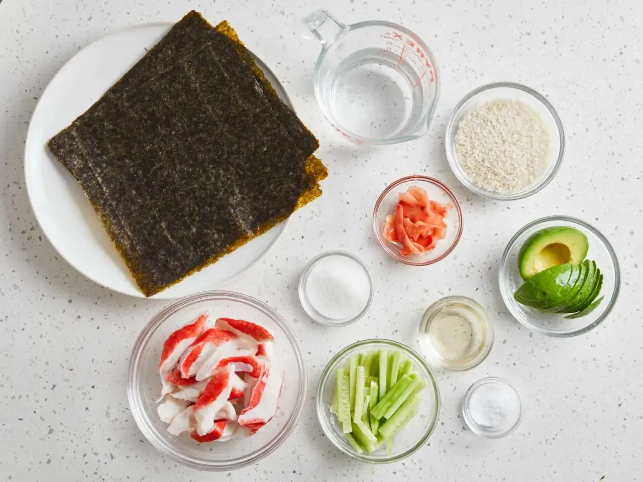 Składniki do domowego sushi: ryż, nori, awokado, paluszki krabowe, ogórek, imbir, ocet ryżowy, cukier i sól.