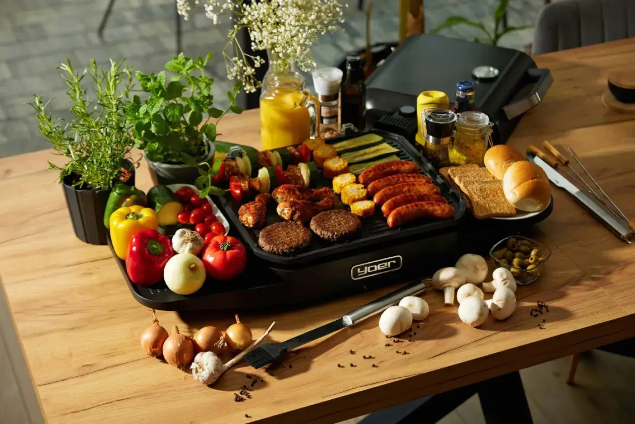 Pyszne kiełbaski, burgery i szaszłyki na grillu elektrycznym. Obok świeże warzywa, pieczywo i dodatki. Idealne na letnie grillowanie.