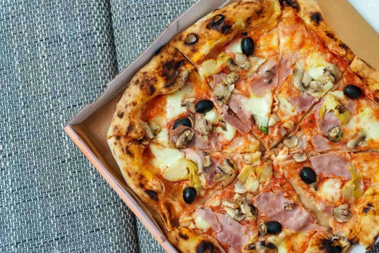 Pizza capriciosa z szynką, pieczarkami, karczochami i czarnymi oliwkami.