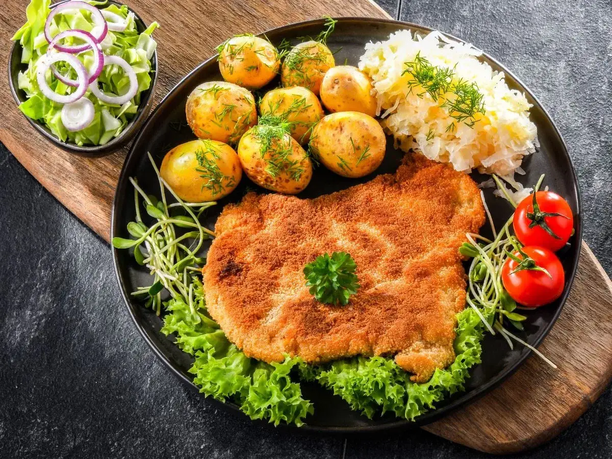 Obiad jak u babci: panierowany kotlet, ziemniaczki, surówka i kapusta kiszona. Stare przepisy na obiad zawsze smakują najlepiej.