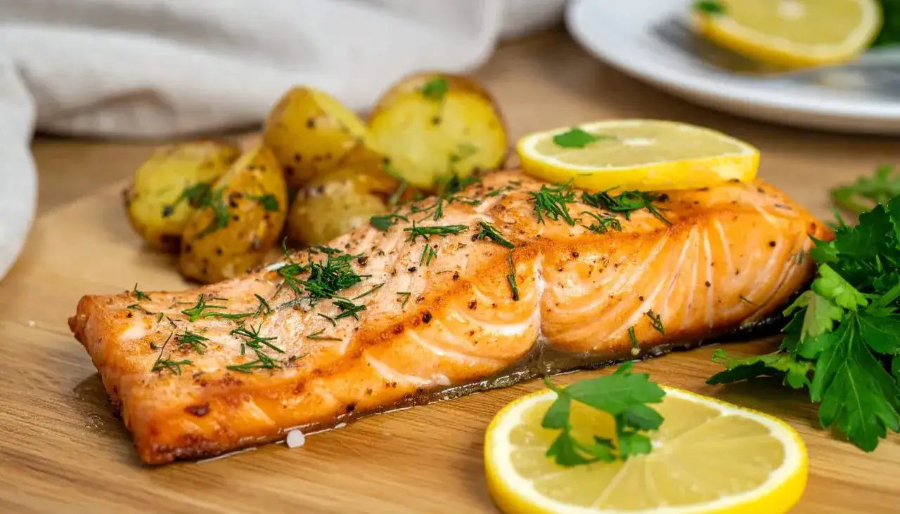 Soczysty łosoś z airfryer, podany z pieczonymi ziemniaczkami, cytryną i świeżą natką pietruszki. Idealny obiad w kilka minut.