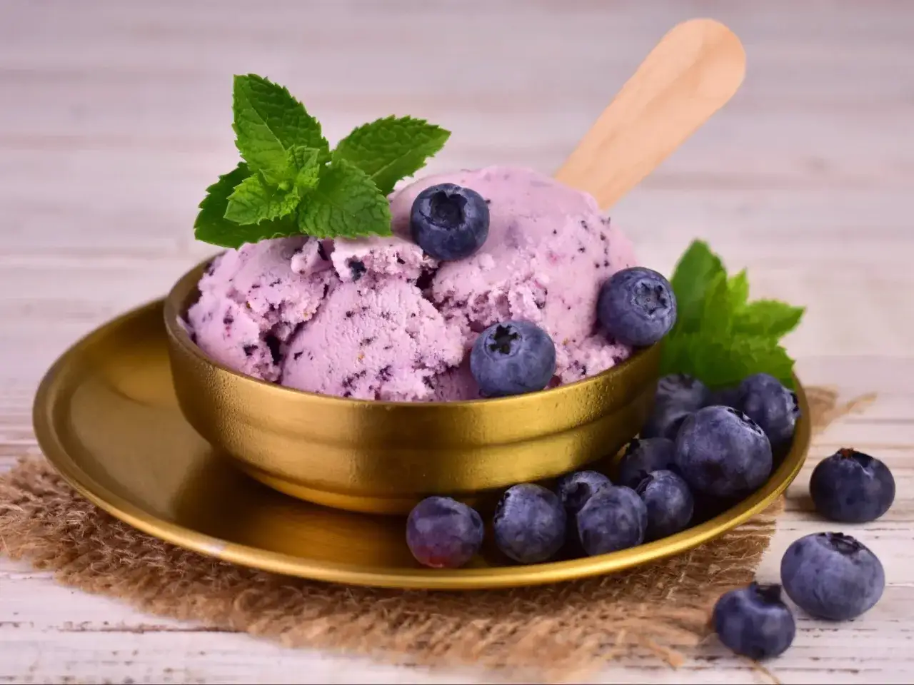 Pyszne, domowe lody jagodowe z miętą i świeżymi owocami. Idealne na letnie popołudnie.