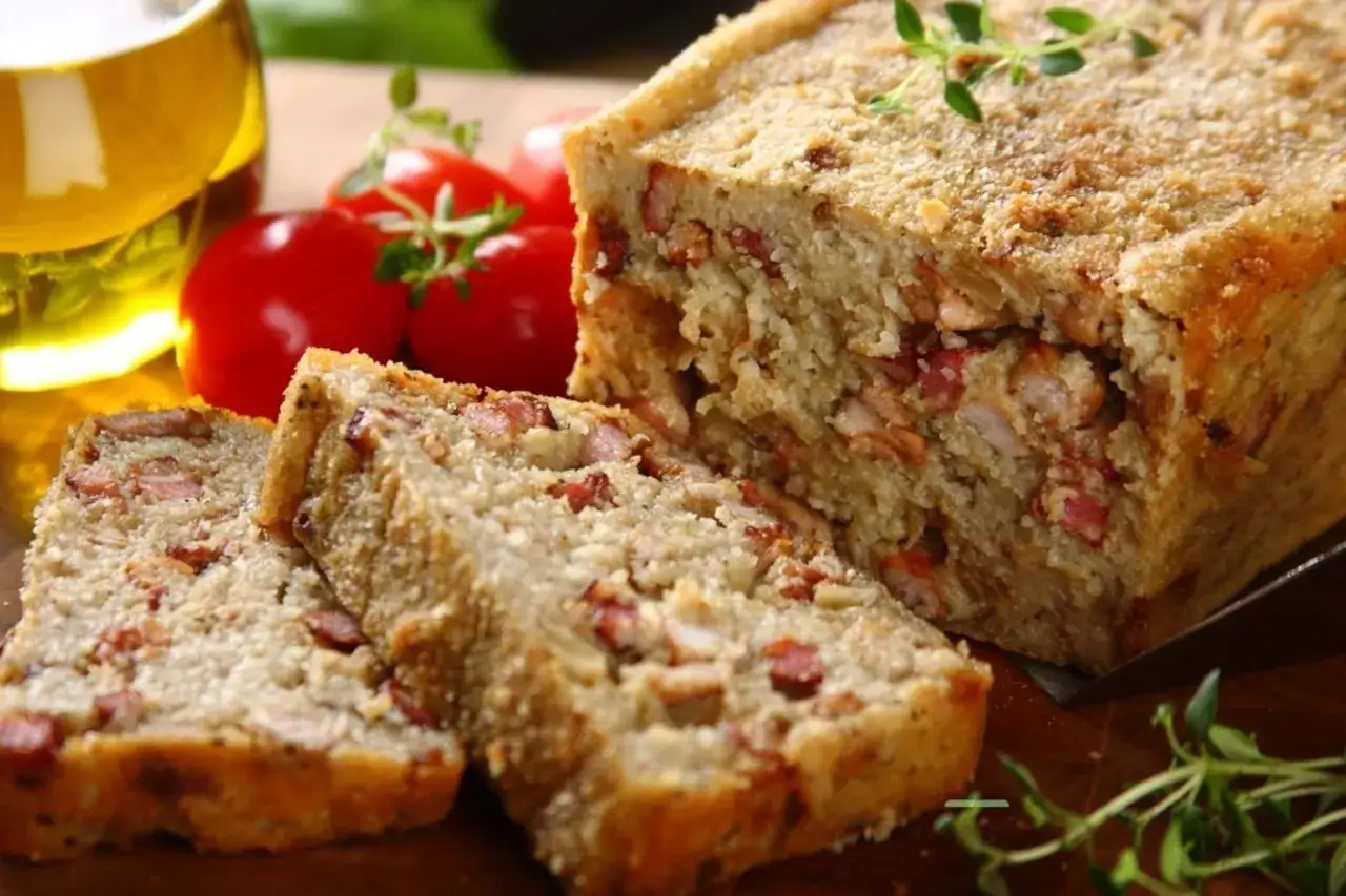 Pyszny, domowy kartoflak z kawałkami boczku i kurczaka, podany z pomidorami i oliwą.