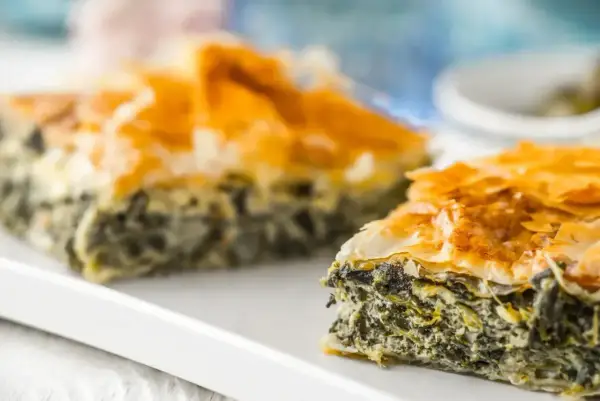 Chrupiąca, złocista spanakopita z warstw ciasta filo i aromatycznym nadzieniem ze szpinaku i sera feta.